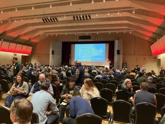 full auditorium with people talking informally