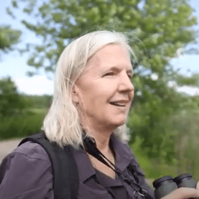 headshot of Laura Johnson against backdrop of trees & open space